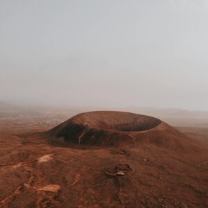 Stunning aerial view of Calderon Hondo volcano amidst a foggy, arid landscape in Spain.