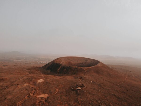 Stunning aerial view of Calderon Hondo volcano amidst a foggy, arid landscape in Spain.